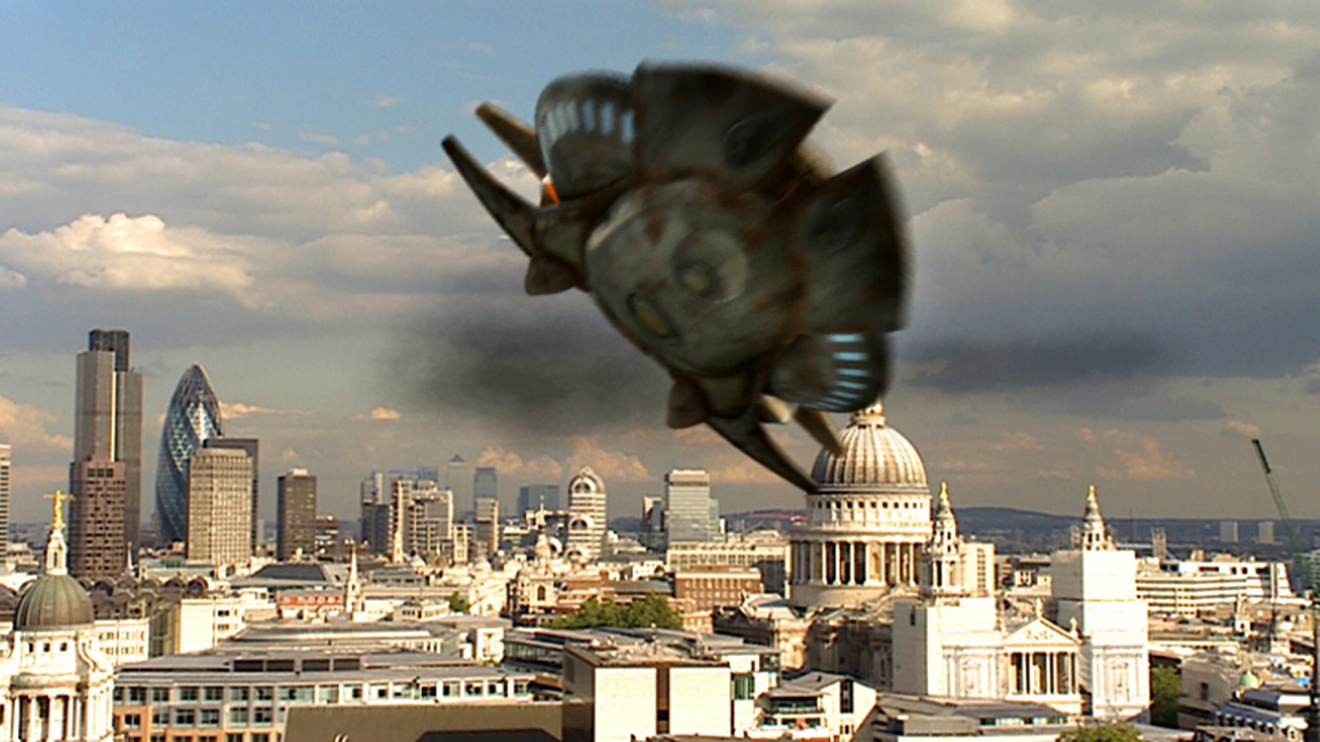 Screencap from Aliens of London: a large gray alien spaceship soars over London, seen from below.
